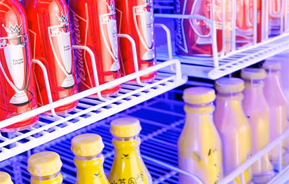 Stainless steel commercial beverage cooler with multi-color LED lighting and customizable glass door panel in a modern bar setting