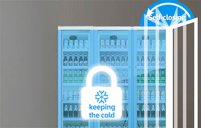 Stainless steel commercial beverage cooler with self-closing glass door and LED lighting, displaying bottled drinks in a busy supermarket environment